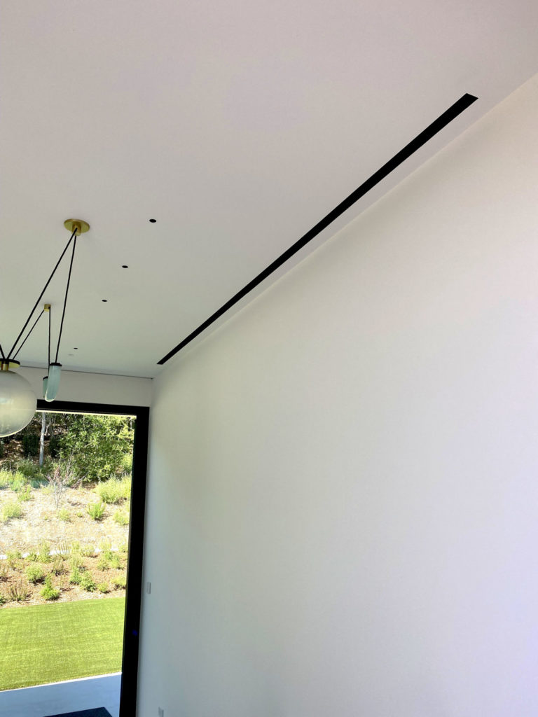 Thin linear diffusers in the ceiling of this Atherton home.
